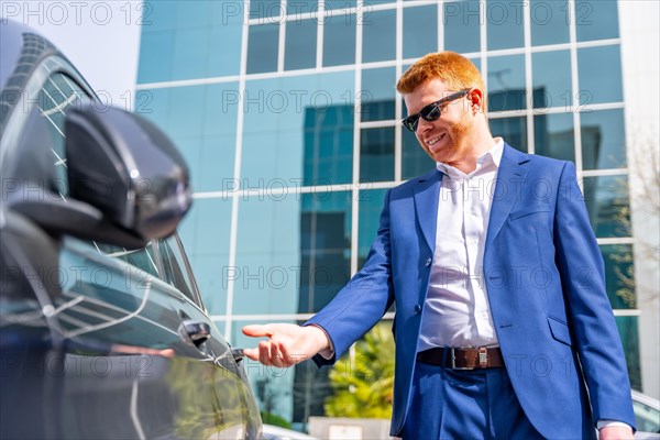 Businessman opening the door of a car after work in the city