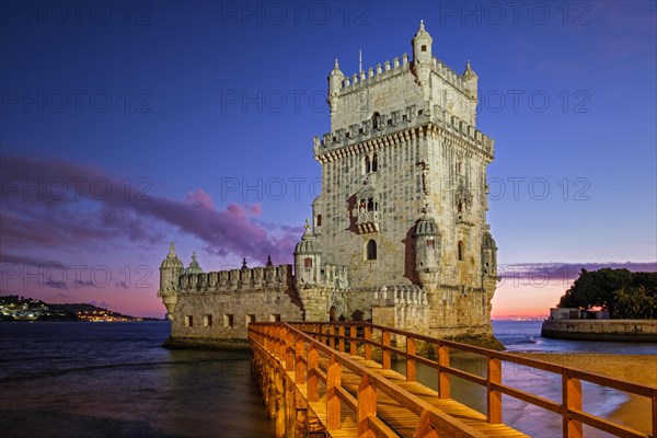 Belem Tower or Tower of St Vincent famous tourist landmark of Lisboa and tourism attraction on bank of Tagus River (Tejo) after sunset in dusk twilight with dramatic sky. Lisbon, Portugal, Europe