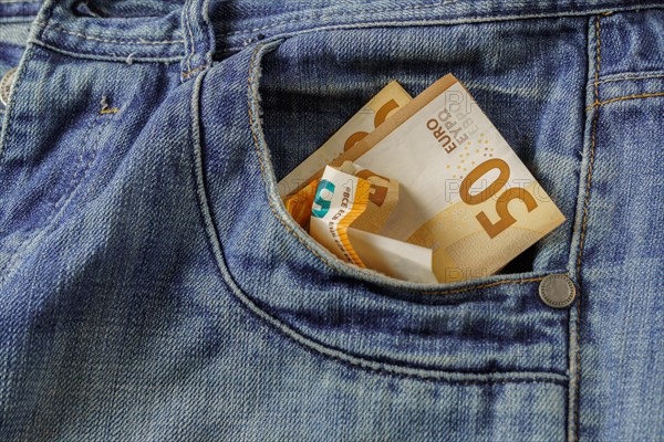 Jeans with euro banknotes coming out of the pocket