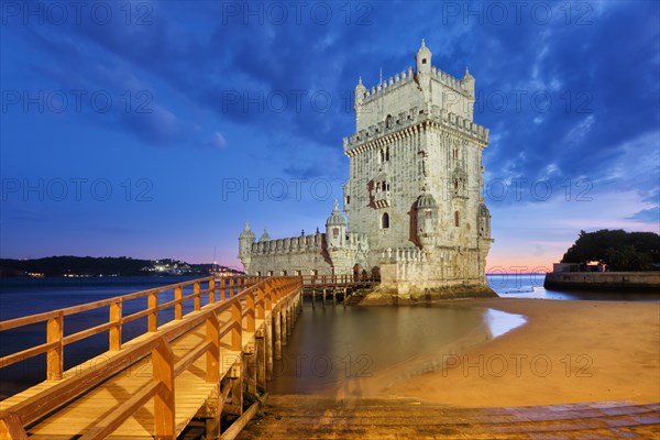 Belem Tower or Tower of St Vincent, famous tourist landmark of Lisboa and tourism attraction, on the bank of the Tagus River (Tejo) after sunset in dusk twilight with dramatic sky. Lisbon, Portugal, Europe