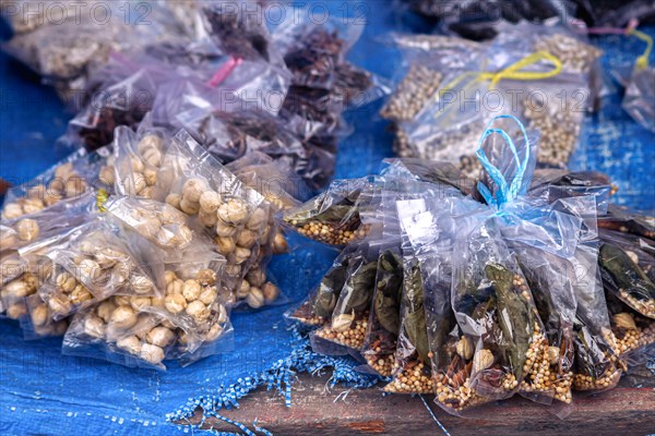 Assorted plastic bags of different dried spices and herbs like Aleurites moluccanus or candlenut, laurel leaves, pepper and star anise that are use as traditional alternative medicines in North Sumatra, Indonesia, Asia