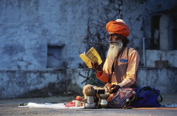 Hindu ascetic reading hindu scriptures, sadhu at pushkar, Rajasthan, India, Asia