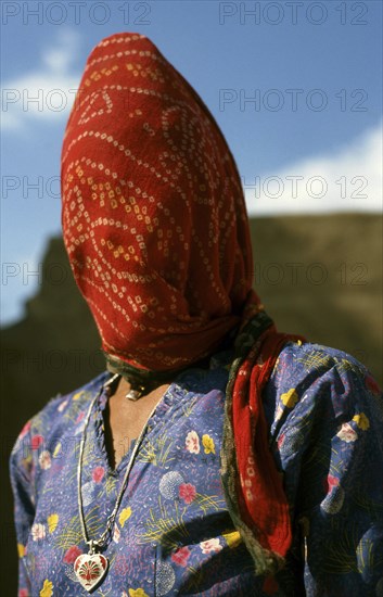 Portrait of a married hindu woman. She is wearing a ghoonghat, a long scarf that is covering her head, northern Rajasthan, India. The goal of the facial veiling is to limit the interactions between respectable women and men that dont belong to the family