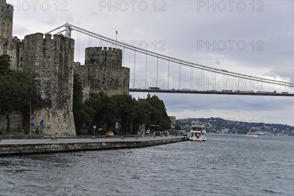 A medieval castle with a small boat on the water in front of a bridge, Istanbul, Istanbul Province, Turkey, Asia