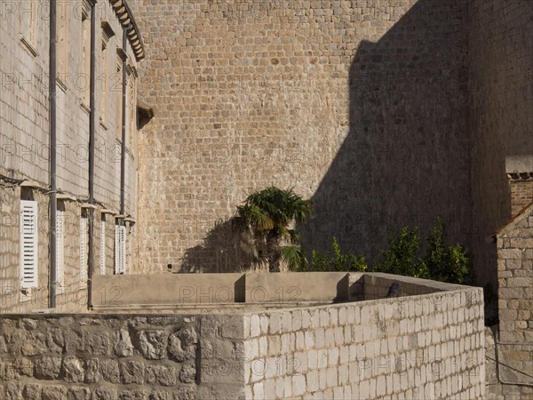 Stone walls and a small building with shadows and lots of texture, the old town of Dubrovnik with historic houses, churches, red roofs and fortress walls, dubrovnik, coratia