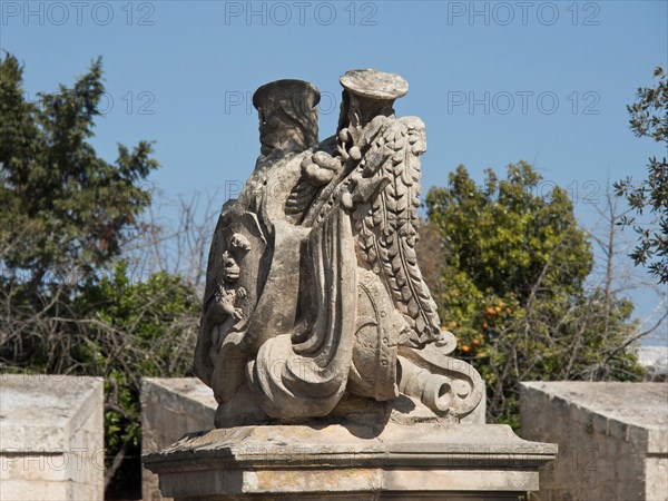 Stone sculpture of an eagle with outstretched wings in a natural setting with trees, the town of mdina on the island of malta with historic houses, colourful balconies, magnificent churches, mdina, Malta, Europe