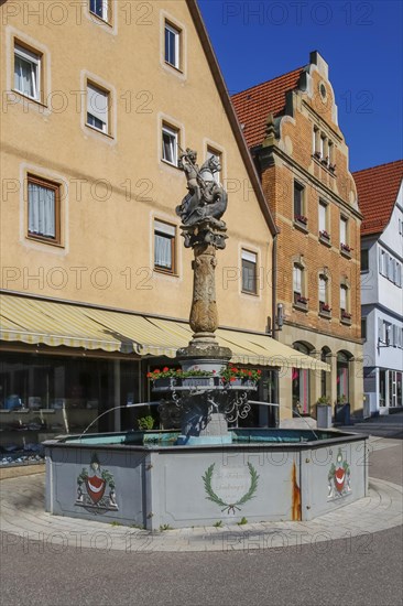 St George's Fountain, dragon slayer, column of the four-tube fountain, statue of St George by Jakob Mueller original from 1594, copy from 1952, octagonal cast-iron trough, from 1816, inscription by Amtmann Carl Ferdinand Sandberger, reference to the historical water supply, Renaissance fountain, main street, cobblestones, Boennigheim, Ludwigsburg district, Baden-Wuerttemberg, Germany, Europe