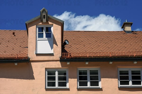 Red facade and tiled roof with crane dormer in the Muehlberg ensemble is a heritage-protected group of late medieval houses, Kempten, Allgaeu, Bavaria, Germany, Europe