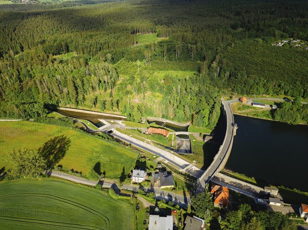 The Malter Dam is a dam built between 1908 and 1913 in the Free State of Saxony near the town of Malter, which impounds the middle reaches of the Rote Weisseritz. The dam is a curved gravity dam made of quarrystone masonry according to the Intze principle. It is an important element in flood protection up to the Elbe. Due to the current weather conditions, additional water is being drained off. Heavy rain showers and continuous rain are advancing from the Ore Mountains in the sky, Malter, Saxony, Germany, Europe