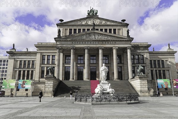 The concert hall am Gendarmenmarkt in Berlin, Germany, Europe, Majestic concert hall in Berlin with magnificent columned facade and statue, blue sky with clouds, Berlin, Europe