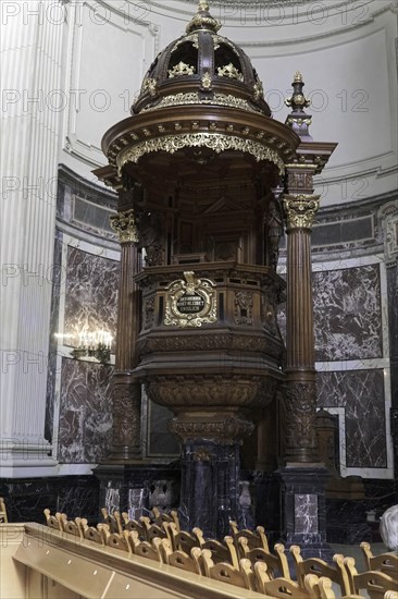 Interior view of Berlin Cathedral, Berlin, Germany, Europe, Richly decorated wooden pulpit in a church with golden elements, marble walls and rows of benches, Europe