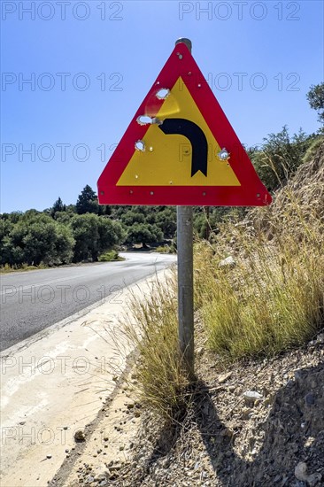 Bullet holes in road sign is target for target practice of bullets shot through, Crete, Greece, Europe