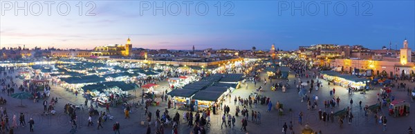 Marrakech, Morocco, March 27, 2018: Panoramic high angle dusk view over Jemaa El-Fna square at evening in historic old town medina, Africa