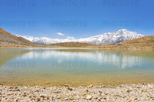 A pristine alpine lake reflects the surrounding Himalayan mountains. The lake is a pilgrimage point among Buddhists around Dhankar, Spiti Valley, Himachal Pradesh, India, Asia