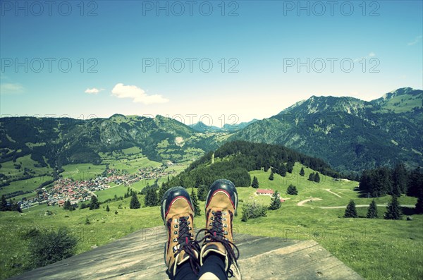 Mountain boots on alpine pasture with blue sky