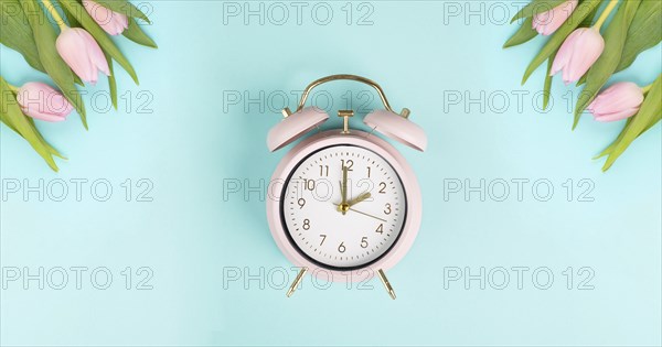 Alarm clock with tulips, switch to daylight saving time in spring, summer time changeover