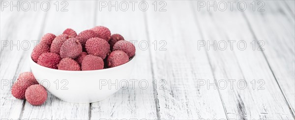 Litchis on an old wooden table as detailed close-up shot (selective focus)