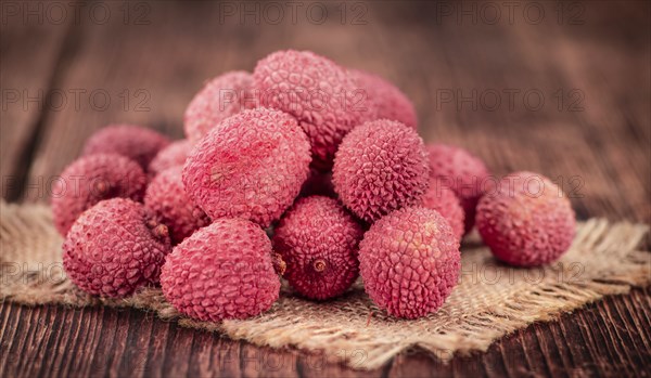 Litchis on rustic wooden background (close-up shot)