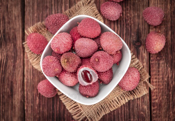 Litchis on rustic wooden background (close-up shot)