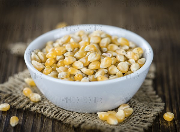 Portion of Corn (detailed close-up shot) on wooden background (selective focus)