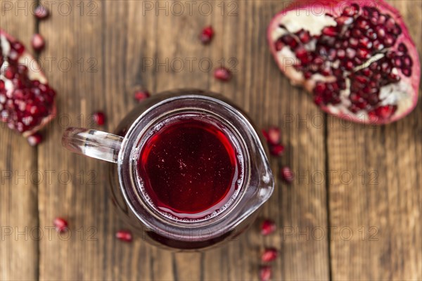 Fresh made Pomegranate juice on a vintage background (close-up shot)