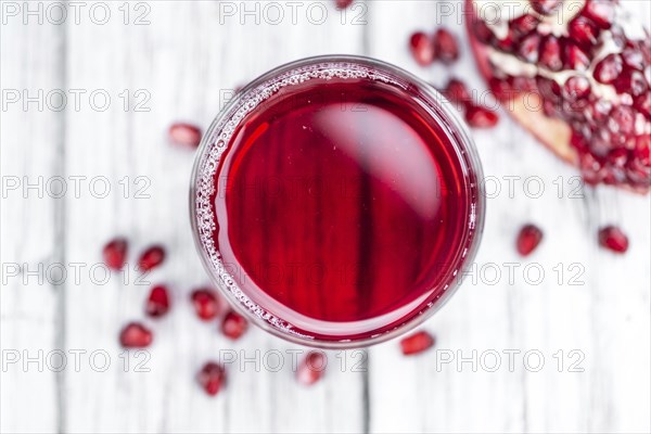 Pomegranate juice on a vintage background as detailed close-up shot (selective focus)