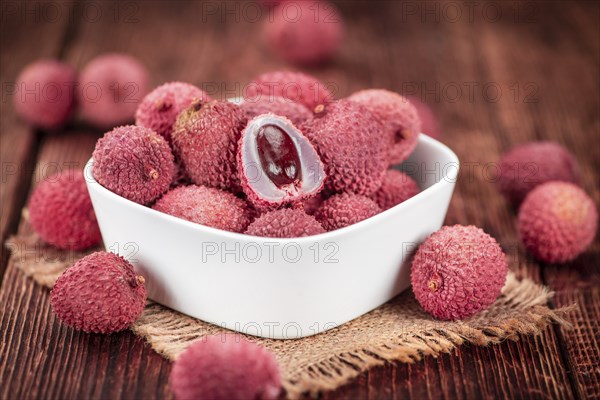 Lychees on a vintage background as detailed close-up shot (selective focus)