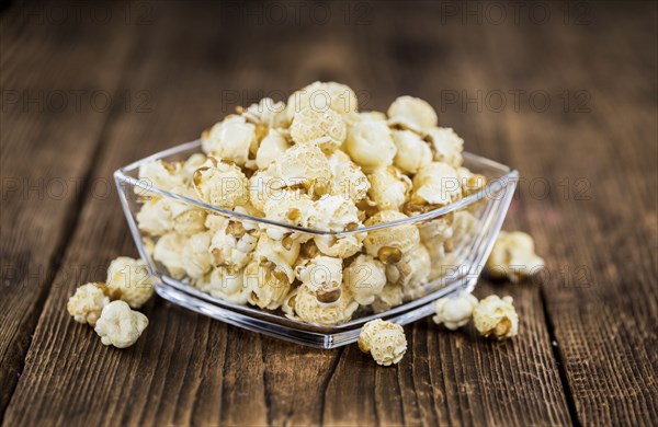 Popcorn as high detailed close-up shot on a vintage wooden table, selective focus