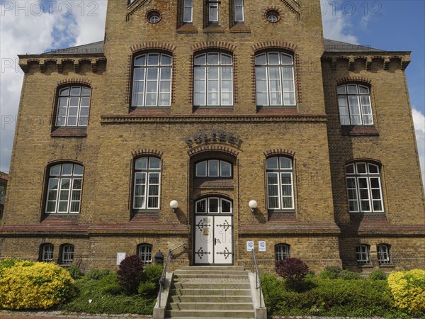 Historic brick building with numerous windows and stairs in a well-kept garden, Kappeln, Schleswig-Holstein, Germany, Europe