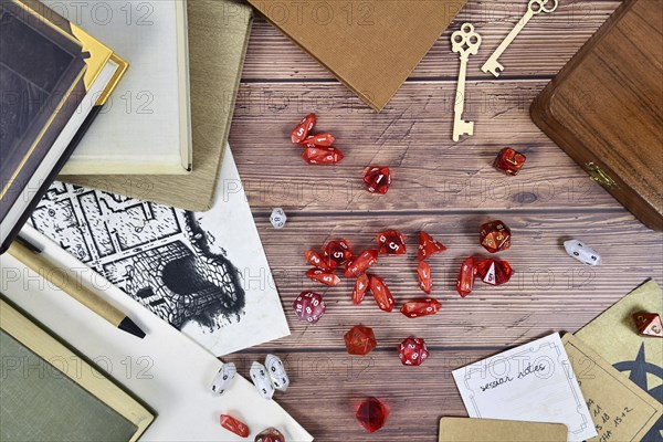 Tabletop role playing flat lay background with red RPG dices, rule books and notes on wooden background