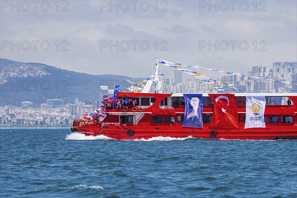 Supporters of the ruling AK party waving turkish flags on a red boat before presidential elections