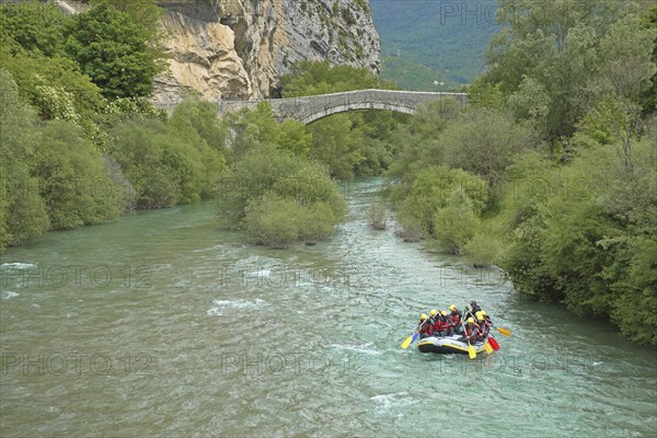 Stone arch bridge Pont du Roc built in the 15th century over the river Verdon with rafting group in a rubber dinghy, Castellane, Provençal Alps, Western Alps, Alps, Route Napoléon, Alpes-de-Haute-Provence, Provence, France, Europe