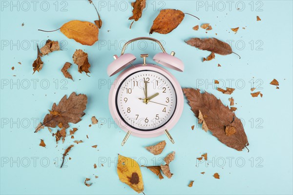 Alarm clock with autumn foliage, end of daylight saving time in fall, winter time changeover