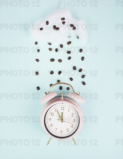 Wake up, time for a coffee break, alarm clock with roasted beans raining from a cloud