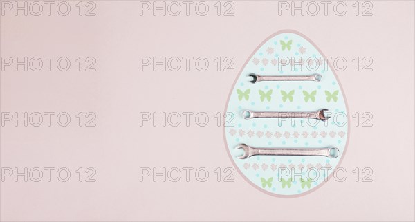 Easter egg with wrenches and butterflies, holiday greeting card with repair tools, spring season