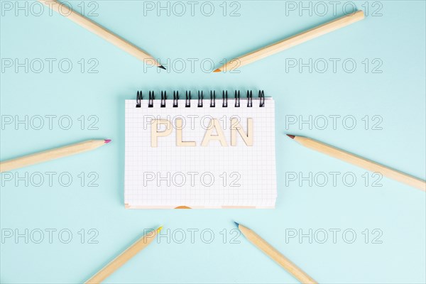 Plan is standing in a notebook, planning new goals, to do list, colorful pencils, new year resolutions