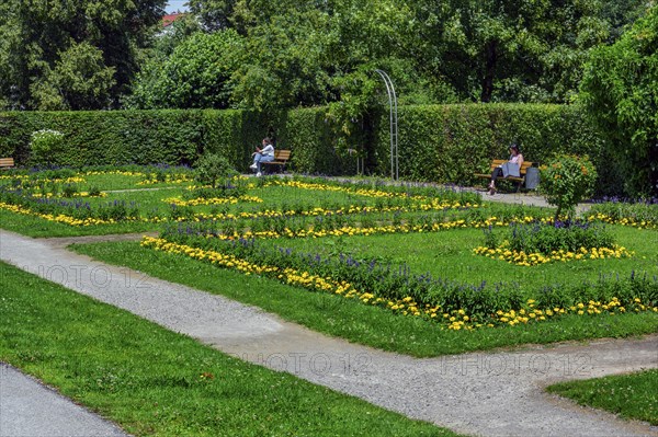 Visitors sunbathe in the flower beds in the courtyard garden, Kempten, Allgäu, Bavaria, Germany, Europe