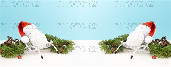 Santa Claus with a red hat sitting in a lounge chair, holiday by the sea, taking a vacation, christmas decoration with fir, cones and stars