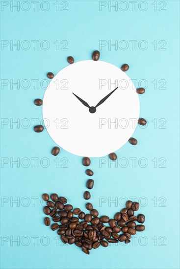 Alarm clock flower made from coffee beans, wake up in the morning, having a deadline, time for a break, minimalistic concept, blue background