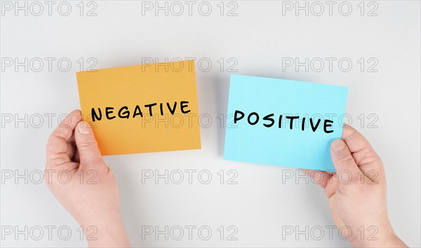 The words negative and positive are standing on paper, business and service rating, evaluation concept, marketing, having an optimistic mindset