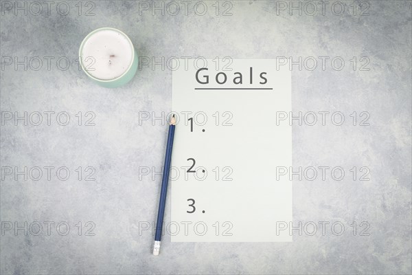 Empty paper with a pen on a textured background, the word goal is standing on the top of the page, planning new targets, to do list, cup of coffee