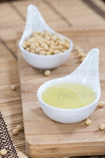 Golden Soy Oil on dark wooden background (close-up shot)