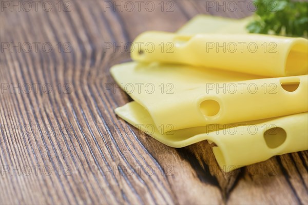 Sliced Cheese (close-up shot) on vintage wooden background