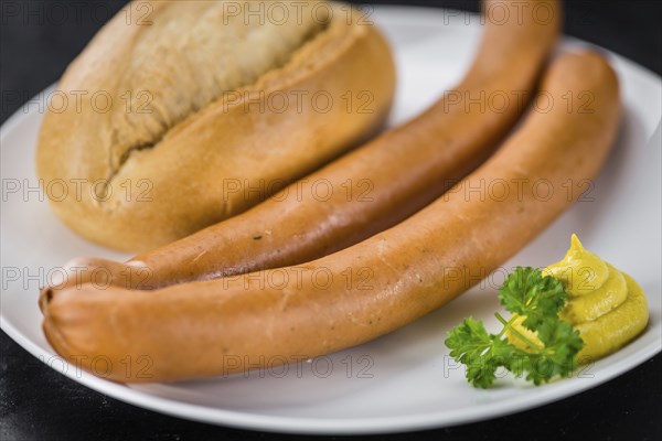 Sausages (Frankfurter) on a vintage slate slab (close-up shot, selective focus)