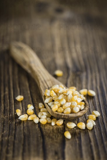 Dried Corn (detailed close-up shot, selective focus) on vintage wooden background