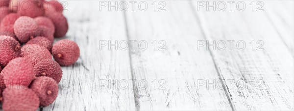 Litchis on an old wooden table as detailed close-up shot (selective focus)