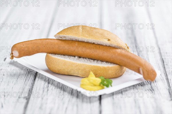 Sausages (Frankfurter) on rustic wooden background (close-up shot)