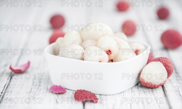 Litchis on rustic wooden background (close-up shot)