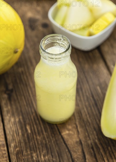 Honeydew Melon smoothie (close-up shot, selective focus) on a wooden table