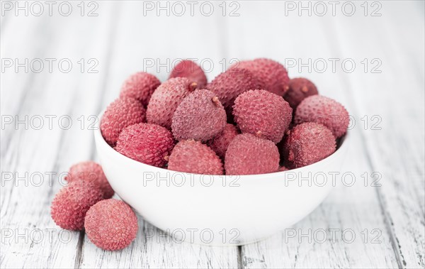 Litchis on rustic wooden background (close-up shot)